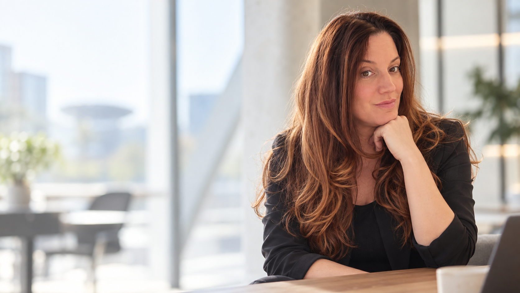 Nancy Brouwers aan tafel in een moderne, lichte werkomgeving